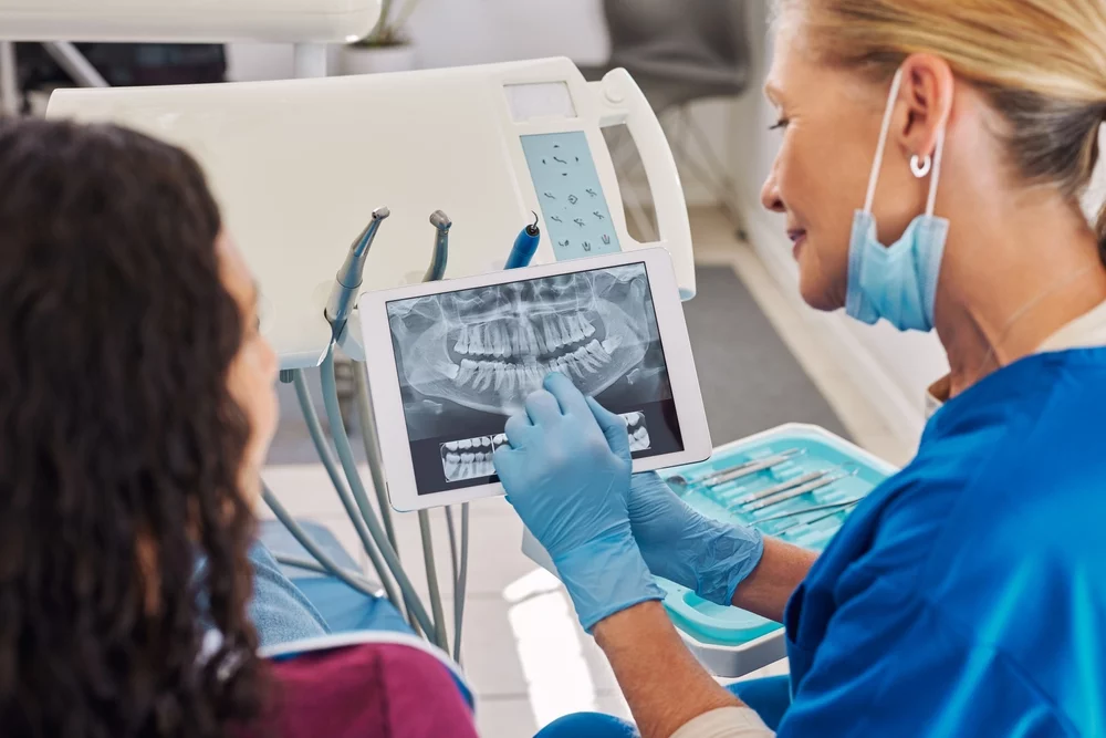 Dentist showing x-ray image to patient