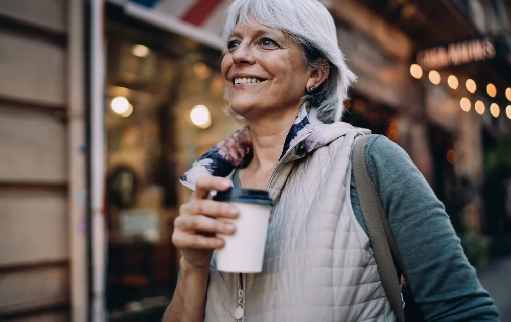 Woman out smiling while having her coffee