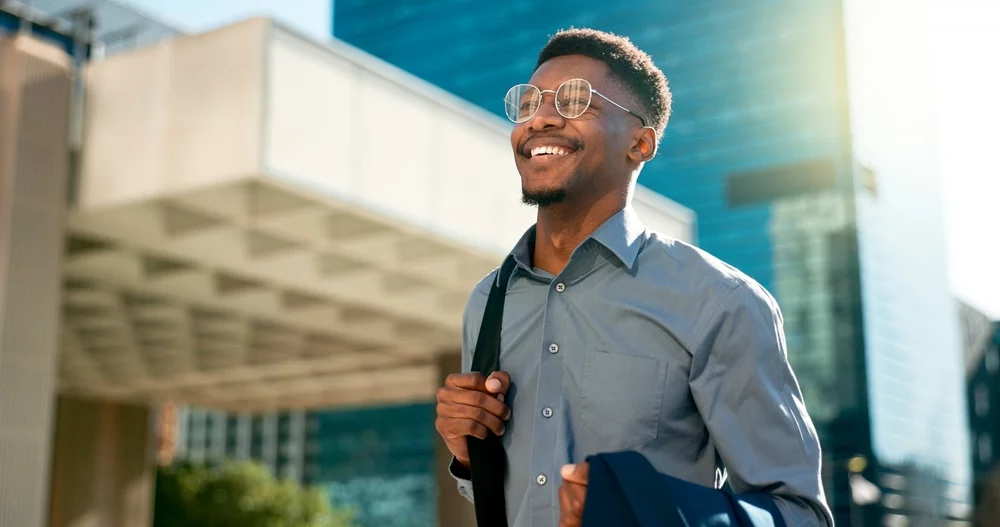 Happy businessman walking through the city